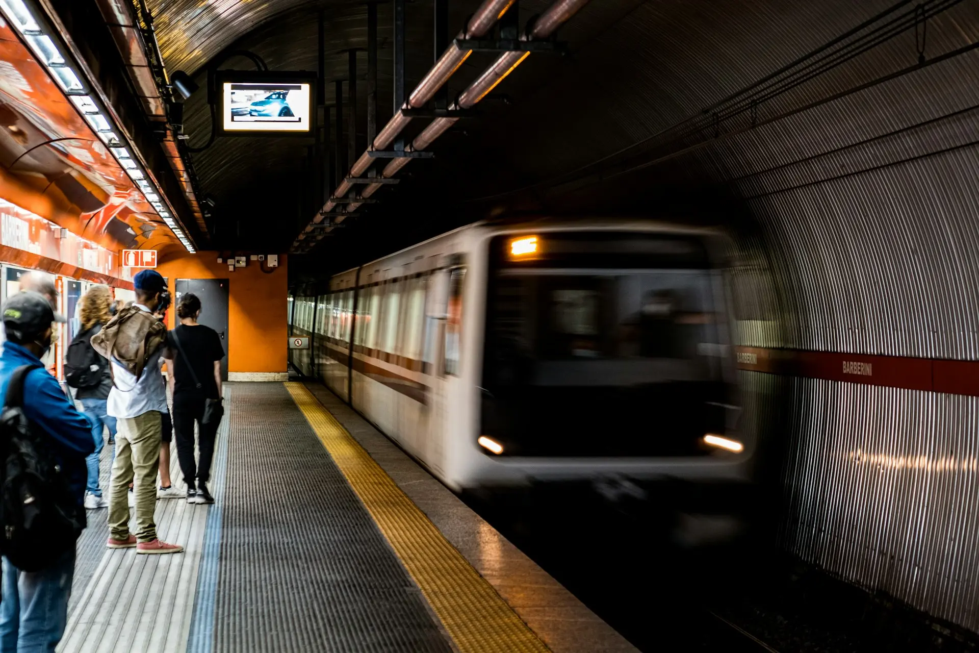 a group of people waiting to board a train